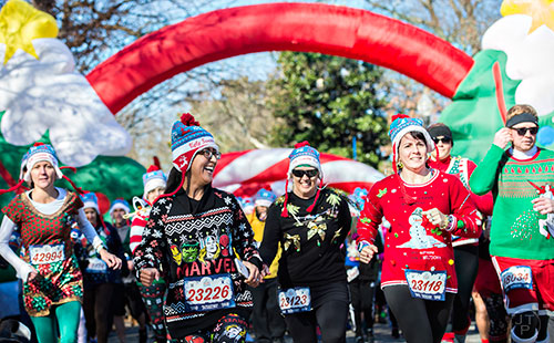 Carmen Garcia (left) takes off from the starting line during the Ugly Sweater Run at Piedmont Park in Atlanta on Saturday, December 19, 2015. 