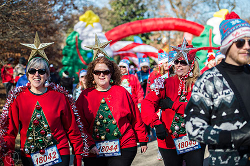 Barbara Shannon (left), Cathy Shirah and Cheri Stinson take off from the starting line during the Ugly Sweater Run at Piedmont Park in Atlanta on Saturday, December 19, 2015. 