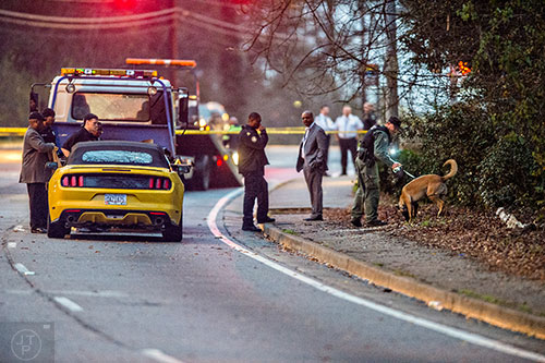 A K-9 unit searches the area around a yellow mustang after a shootout between a car jacking suspect and Atlanta Police on M.L.K. Jr. Dr. in between 285 and Brownlee Rd. in Atlanta on Monday, December 28, 2015.    