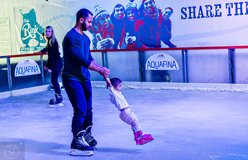 Emmanuel Cabreja (center) spins his niece Ella Rivero on the ice as his wife Arielle watches at the Southwest Rink at Park Tavern in Atlanta on Saturday, December 26, 2015. 