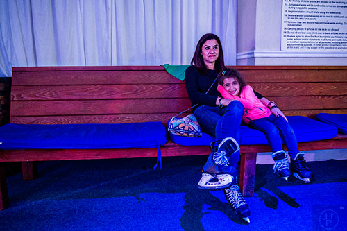 Maya Abboushi (left) sits on a bench with her daughter Leen as they take a short break from ice skating at the Southwest Rink at Park Tavern in Atlanta on Saturday, December 26, 2015. 