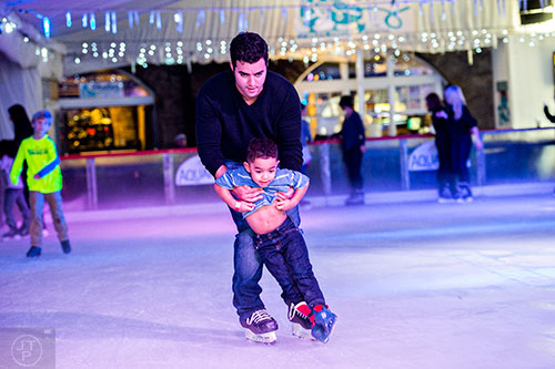 Jon Rivero (center) skates with son Jon Michael at the Southwest Rink at Park Tavern in Atlanta on Saturday, December 26, 2015. 