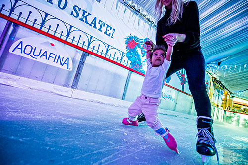 Arielle Cabreja (right) helps her niece Ella Rivero skate on the ice at the Southwest Rink at Park Tavern in Atlanta on Saturday, December 26, 2015. 