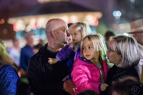 Heather Spiegel (right) holds her daughter Ellie during the Chanukah celebration in Decatur Square on Thursday.