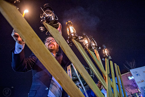 Rabbi Ari Sollish lights the giant menorah in Decatur Square during the Chanukah celebration on Thursday.