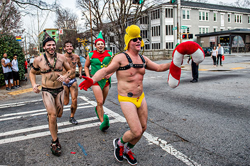 Dressed as Woodstock from The Peanuts, Brad Lewis (right) runs up North Highland Ave. during the annual Atlanta Santa Speedo Run at Manuel's Tavern on Saturday, December 12, 2015.