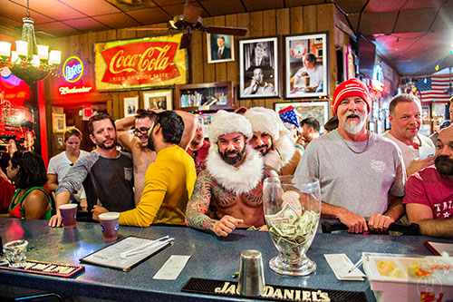 Michael Shane Breazeale (center) and Ahmad Sabha order drinks at the bar after the annual Atlanta Santa Speedo Run at Manuel's Tavern on Saturday, December 12, 2015.