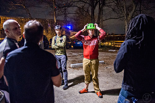 Andrew Beishline (center) checks his helmet as he gathers at Atlanta Beltline Bicycle with around 50 other cyclists before the annual Atlanta Christmas Ride on Wednesday evening.