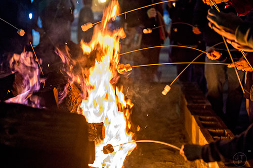 People hold onto their sticks during the annual marshmallow roast at Decatur Square on Thursday.