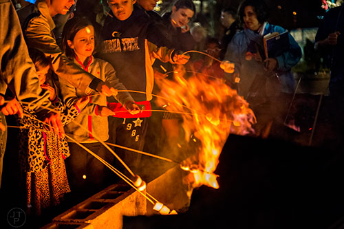 Genevieve Uhlenbrock (left) holds onto her stick during the annual marshmallow roast at Decatur Square on Thursday.
