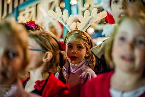 Amelia Russell (center) sings Christmas carols during the annual marshmallow roast at Decatur Square on Thursday.