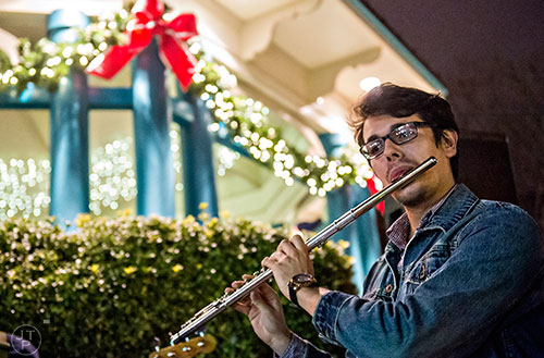 Cain Bergeron plays the flute during the annual marshmallow roast at Decatur Square on Thursday.