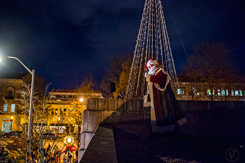 Santa Claus speaks to the crowd from the roof of Little Shop of Stories in downtown Decatur during the annual lighting of the tree on Thursday.