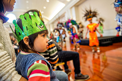 Clara Trzecieski (left) sits on her mother's lap as she watches a traditional Aztec dance during the Dia de los Reyes, or Three Kings Day, celebration at the Atlanta History Center on Sunday, January 10, 2016. 