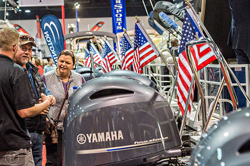 Brenda Chester (right) and her husband David talk to Michael Norris about the engine on one of the boats on display during the 54th annual Atlanta Boat Show at the Georgia World Congress Center in Atlanta on Saturday, January 16, 2016. 