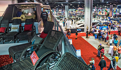 Tyler Gibson (center) walks on the upper deck of a Axiom Yacht 70 during the 54th annual Atlanta Boat Show at the Georgia World Congress Center in Atlanta on Saturday, January 16, 2016. 