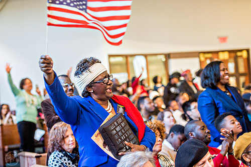 G.A. Breedlove (left) waves an American flag as Dr. Bernice King speaks during the 48th Martin Luther King Jr. Annual Commemorative Service at Ebenezer Baptist Church in Atlanta on Monday, January 18, 2016.