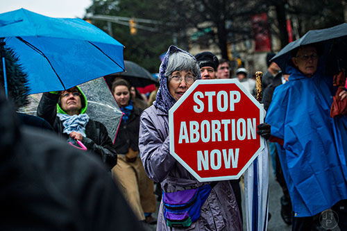 Janice McFarland (center) holds a pro life sign as she marches down Martin Luther King Jr. Dr. during the Georgia March for Life in Atlanta on Friday, January 22, 2016. 