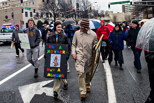 Jonathan Sims (center left) and Orlando Aguirre walk up Piedmont Ave. during the Georgia March for Life in Atlanta on Friday, January 22, 2016. 