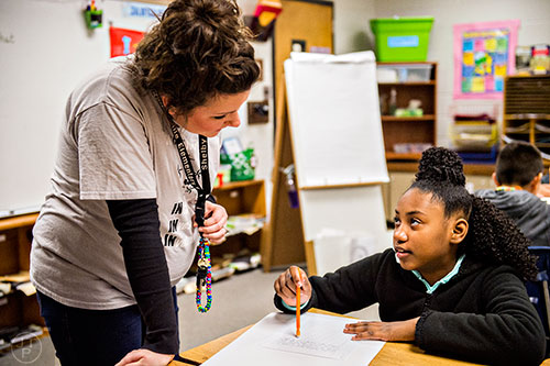 Shelby Stephens (left) works with Janye Ingram during her fourth grade class at Centerville Elementary School in Snellville on Friday, January 22, 2016. 