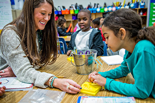First grade teacher Christine Ross (left) helps Aryn Scarabin with a math problem during class at Centerville Elementary School in Snellville on Friday, January 22, 2016. 
