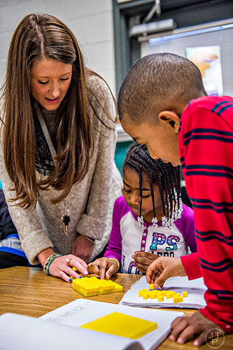 First grade teacher Christine Ross (left) helps Brielle Timmons and Dadmawi Mesay with a math problem during class at Centerville Elementary School in Snellville on Friday, January 22, 2016. 