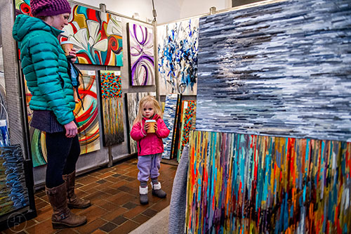 Grier James (left) and her daughter Hannah Joy look at paintings by Gina and Aaron Krawez during the Callanwolde Arts Festival in Atlanta on Saturday, January 23, 2016. 