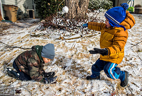 Max Liesemeyer (right) tries to hit his brother Gabriel with a snowball as they play in the snow in Cumming on Saturday, January 23, 2016. 