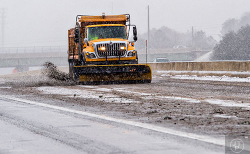 A snow plow treats the access roads along GA400 in Cumming on Saturday, January 23, 2016. 