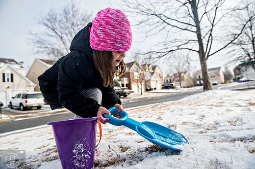 Ansley Olver shovels snow into a bucket at her home in Cumming on Saturday, January 23, 2016.