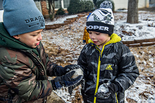 Gabriel Liesemeyer (left) and Charlie Edwards try to get their snowballs to stick together as they play in the snow in Cumming on Saturday, January 23, 2016. 