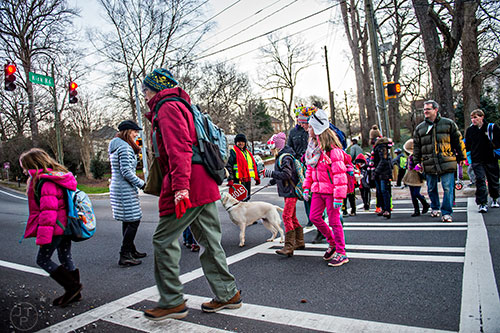 A large group of people cross S. Candler St. at Kirk Rd. in Decatur on their way to school during the Big Walk on South Candler event on Wednesday morning.