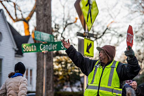 Maurice Johnson (right) stops traffic at the intersection of S. Candler and E. Dougherty streets in Decatur so people can cross on their way to school during the Big Walk on South Candler event on Wednesday morning.