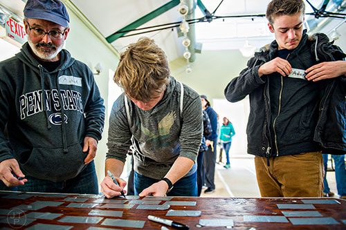 Michael Murphy-McCarthy (left), his son Aidan (right) and Thomas Lloyd put on their name tags before the start of the 14th annual Martin Luther King Jr. Service Project on Sunday.