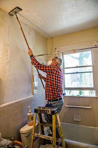 Chuck Warner works to remove paint at one of the 33 houses in Decatur during the 14th annual Martin Luther King Jr. Service Project on Sunday.
