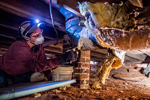 Beth Faircloth helps seal air conditioning ducts in the crawl space of a house during the 14th annual Martin Luther King Jr. Service Project on Sunday.