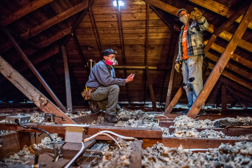 Frank Burdette (left) and Mike Barcik size up the state of an attic in a house off of S. McDonough St. in Decatur during the 14th annual Martin Luther King Jr. Service Project on Sunday.