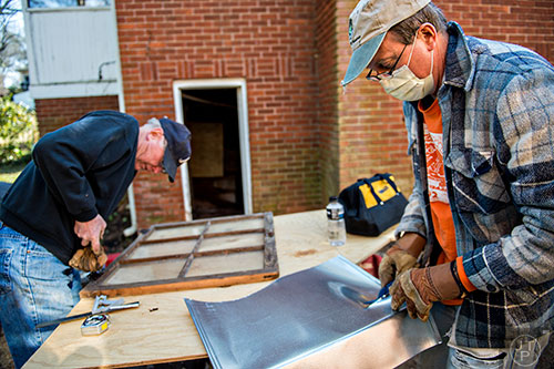 Mike Barcik (right) and Bob Reardon work on different projects to help rehab a house off of S. McDonough St. in Decatur during the 14th annual Martin Luther King Jr. Service Project on Sunday.