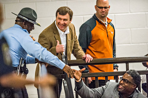 University of Georgia's new head coach Kirby Smart (center) gives a thumbs up as he joins Derrick Brown's parents at the Lanier basketball game against Gainesville on Thursday, January 28, 2016. 