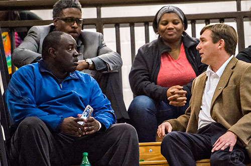 University of Georgia's new head coach Kirby Smart (right) talks to Derrick Brown's mother Martha, father James and UGA defensive line coach Tracy Rocker as they watch him play during the Lanier basketball game against Gainesville on Thursday, January 28, 2016. 