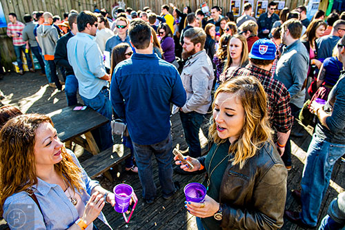Alex Bayyoud (left) talks with Becky Justice as people stand in line to get a sample of different beers during the Atlanta Winter Beer Fest at The Masquerade in Atlanta on Saturday, January 30, 2016. 