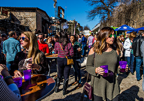 Olivia Calbario (right) walks through the crowd carrying glasses of beer during the Atlanta Winter Beer Fest at The Masquerade in Atlanta on Saturday, January 30, 2016. 