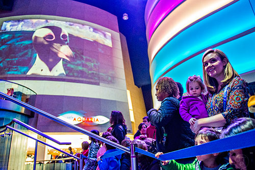 Merideth Ray (right) holds Rose Schumacher as they wait for Party with the Penguins to start at the Georgia Aquarium in Atlanta on Saturday, January 30, 2016. 