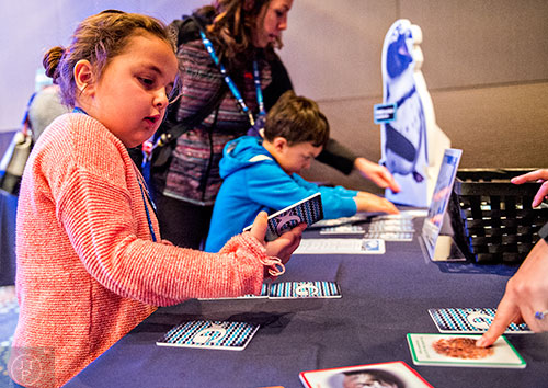 Naomi Sims (left) tries to match a set of cards during Party with the Penguins at the Georgia Aquarium in Atlanta on Saturday, January 30, 2016. 