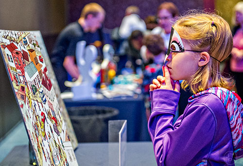 Lily Randle tries to find a penguin hidden in a painting during Party with the Penguins at the Georgia Aquarium in Atlanta on Saturday, January 30, 2016. 