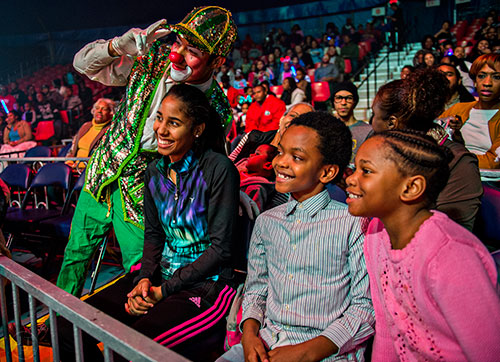 Tempest Jewels (right), her brother Josiah and sister Sabrina interact with one of the clowns during the opening night of the UniverSoul Circus in Atlanta on Wednesday, February 3, 2016. 