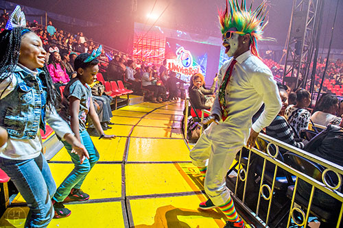 A'Nadia Vearner (left) and Tiffany Best dance with one of the Fresh the Clownsss during the opening night of the UniverSoul Circus in Atlanta on Wednesday, February 3, 2016.  
