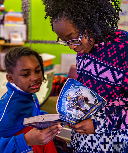 Chasity Brown (right) and Trenyce Neal read a passage from "Rump, the True Story of Rumpelstiltskin" before performing it in front of their class at Powder Springs Elementary School in Powder Springs on Thursday, January 28, 2016. 