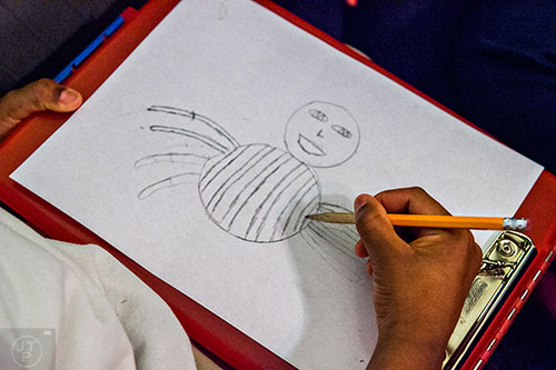 Dequan Gaines draws a bug character with the help of his classmates at Powder Springs Elementary School in Powder Springs on Thursday, January 28, 2016.