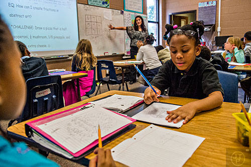 Joyce Mitchell (right) learns about fractions by drawing different sections of a pizza during a math lab at Powder Springs Elementary School in Powder Springs on Thursday, January 28, 2016. 